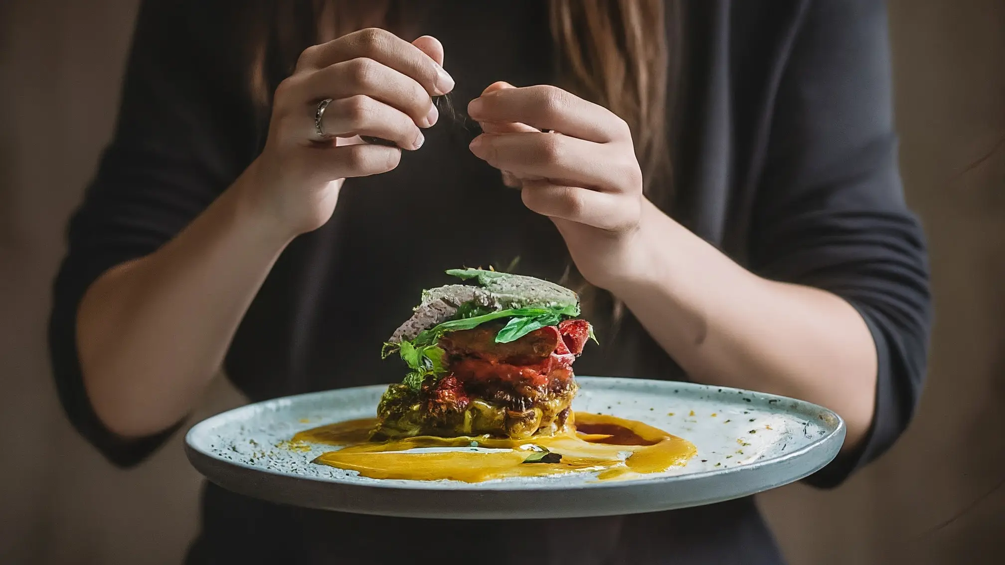 5 Recetas de Calabacín Sin Gluten para Principiantes: ¡Deliciosas y Fáciles! 1 Una mano sosteniendo un plato con rebanadas de calabacín horneado, decorado con hierbas frescas.
